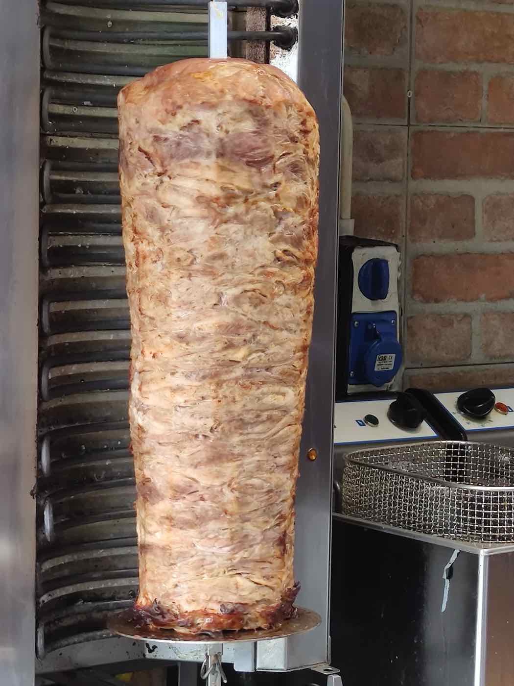 Il cono di carne kebab sullo spiedo verticale nella cucina di La Tosca
