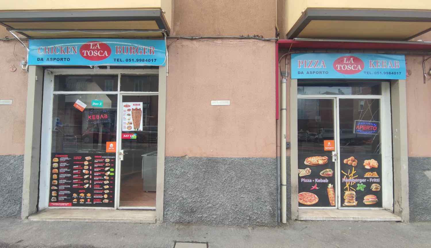 La vetrina di La Tosca in Via Toscana a Bologna, con le insegne blu Pizza Kebab e Chicken Burger